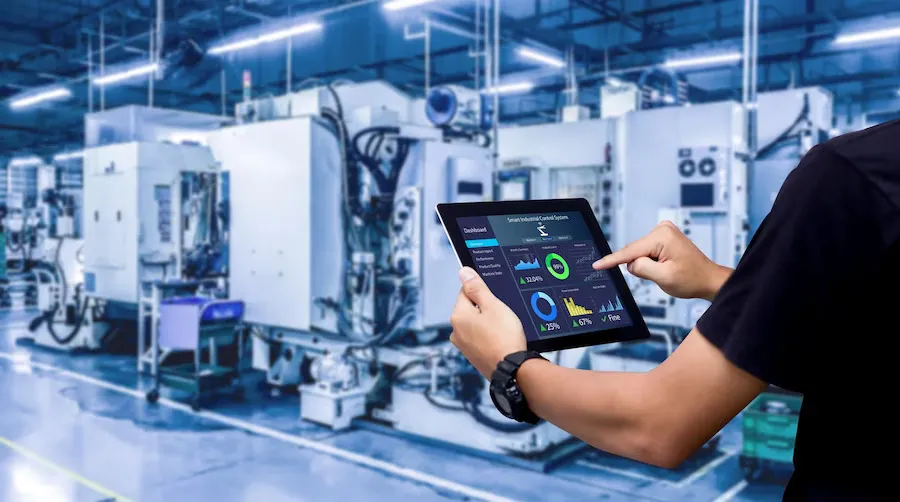 Engineer monitoring factory equipment from a tablet